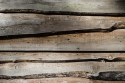 Fragment of a sturdy wooden fence. Horizontal boards are nailed tightly to each other. Wooden background. Blur,