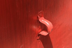Metal pipe clamp fitted on the red painted wall