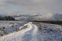 Snow snake path through white valley, mountains in a sunny day. Contrast and shiny day in the snow. Solo adventure