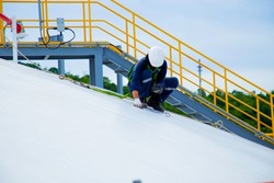Examiner wear fall protection while working on roof of oil storage tank.