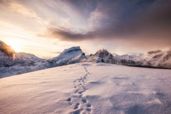 Landscape of snow mountains range with footprint on snowy at sunrise morning