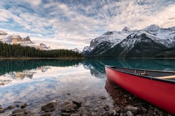 Red canoe parked on Maligne lake with Canadian rockies reflection in Spirit island at Jasper national park, Canada