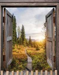 Antique wooden windows open to autumn wilderness at sunrise in national park