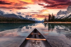 Scenery of Spirit Island with canoe and colorful sky over canadian rockies on Maligne Lake in the sunset at Jasper national park, AB, Canada