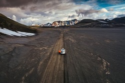 Aerial view of Road trip with tourist 4x4 vehicle car parked on volcanic desert with crater on dirt road in Landmannalaugar at Icelandic Highlands