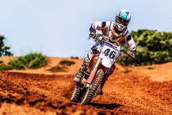 Motocross Rider Speeding Downhill in Mud Track