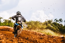 Motocross racer accelerating in dirt track