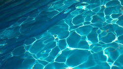 Abstract blue texture of swimming pool water with reflections