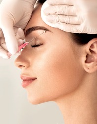 Lifting eyebrow lines using mesothreads. Needle with mesothreads near a female face for contour facial lifting procedure