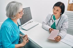 Positive doctor consulting senior woman on results of cardiogram and test. Diagnostic heart diseases, heart attacks, and tachycardia in elderly people