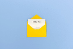 Newsletter concept - Newsletter page looking out of yellow paper envelope