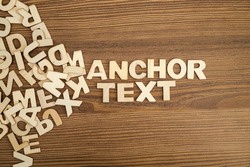 ANCHOR TEXT written with solid letters on a board. Wooden letters on wooden background.