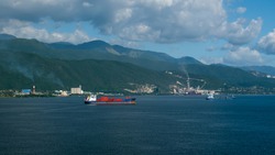 Landscape of Jamaica coast from anchorage and small container ship at the anchor