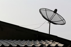 Silhouette of a satellite dish radio telescope antenna facing the sky to receive satellite signals.