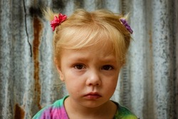 A little girl crying with tears on her face- A little girl wearing pig tails crying with a tear rolling down her face- A sad child glaring into the camera- heart broken