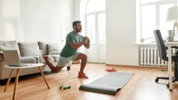 Get Fit At Home. Full length shot of young active man watching online video training on laptop, exercising, stretching during morning workout at home. Sport, healthy lifestyle. Web Banner