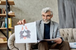 Professional psychotherapist showing inkblot test pictures to patient during session in office, selective focus. Psychotherapy concept