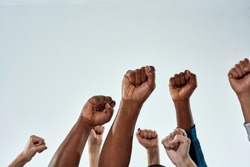 Raised hands of multiracial people clenched into fists on light background. Stop racism concept