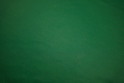 Green football jersey clothing fabric texture sports wear background, close up. Sport Clothing Fabric Texture Background. Top View of Cloth Textile Surface. Green Football Shirt. 