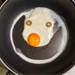 scrambled eggs in a frying pan with a funny face with a smile.