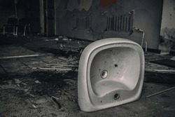 An old white sink in an abandoned building. Broken shell. Interior of an abandoned house.