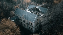 Old brick abandoned manor in the forest. Beautiful top view of an abandoned building. House with the ghosts. Ancient architecture.