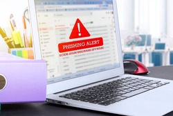 Laptop with warning text on screen PHISHING ALERT scam, spam, malware, spyware. Information poster. High quality photo