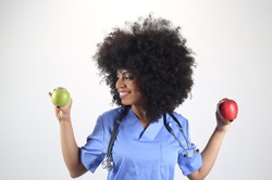 Female doctor with an apple in her hand, afro woman white background, concept of healthy life, health