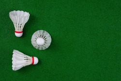 Top view of shuttlecocks arranged on a green badminton court. Flat lay with blank copy space.