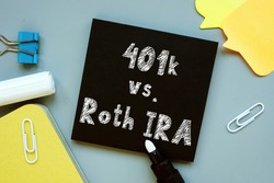Conceptual hand writing showing 401k vs. Roth IRA.