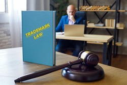 Book with title TRADEMARK LAW . Trademark law governs the use of a device including a word, phrase, symbol, product shape, or logo