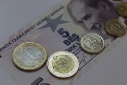 Turkish coins and Banknote. On banknote writes 5 Turkish Lira. Coins 1 Lira, 50, 25, 10, 5, 1 kurush (cent).