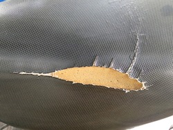 Tear marks at the seams until the sponge texture is visible. closeup of old and torn leather motorcycle seat, Old black leather surface texture background.