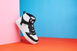 Black and white sneakers on a colored background. Stylish style footwear for advertising a shoe store. Hype sneaker
