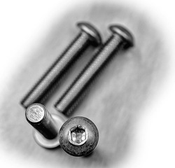 DIN 7380 screw bolt metallic iron close up macro on stainless steel background