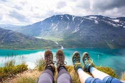 Sport couple hiking on Besseggen. Hikers enjoy beautiful lake and good weather in Norway.

