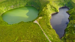 Aerial view of the stunning and sunlit  black and green lake (Lagoa Negra and Lagoa Comprida) on Flores island at the Portuguese achipelago of the Azores in the middle of the Atlantic Ocean