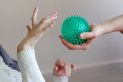 hands of a child with cerebral palsy exercises with a ball development of tactile sensations