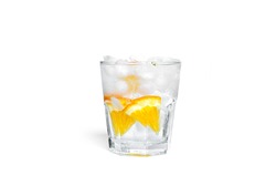 Orange lemonade with ice in a clear glass isolated on a white background. High quality photo