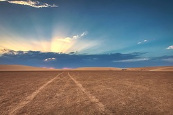 path in the desert towards the sunset with blue sky