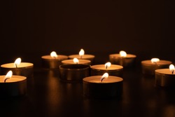 Religious and devoutness scene: candles burning in the dark