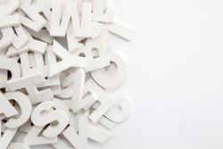 Pile of white painted wooden letters. Typography background composition. 