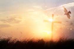 Silhouette christian cross on grass at sunrise background with miracle bright lighting, religion and worship concept