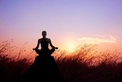 Woman yoga and meditation silhouette on nature sunset background