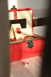 Red jewelry box. White and dark background. Gold jewelry, wedding rings.