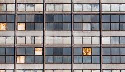 Old windows in a Soviet-era industrial building with a close-up view from the front. Windows of an abandoned industrial building. Windows of a building