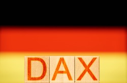 dax index concept. wooden blocks with the word dax on the background of the national flag of germany