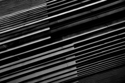 Close-up photo of structural wall of modern building. Abstract futuristic hi-tech architecture. Geometric background with linear pattern, panels, stripes and parallel lines in diagonal composition.