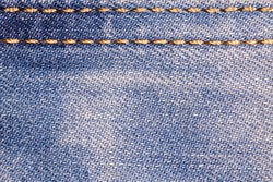 Jeans background. Denim fabric with seams close-up.