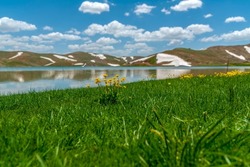 Eğrigöl (eğrigöl), at an altitude of 2,350 meters at the foot of the Geyik Mountain in Antalya province, is surrounded by 3 or 4 meters of snow and mountain wildflowers on one side.